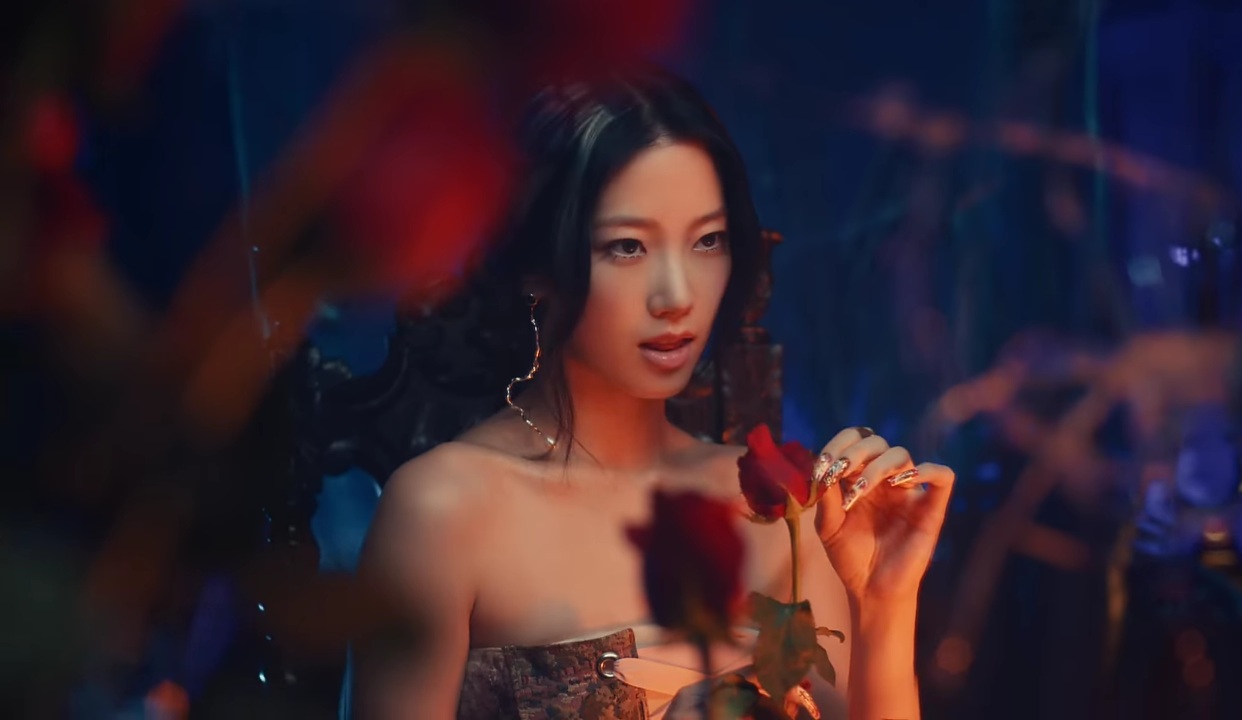 Kazuha is shown picking flower petals while sitting in front of a broken mirror in LE SSERAFIM's EASY music video.