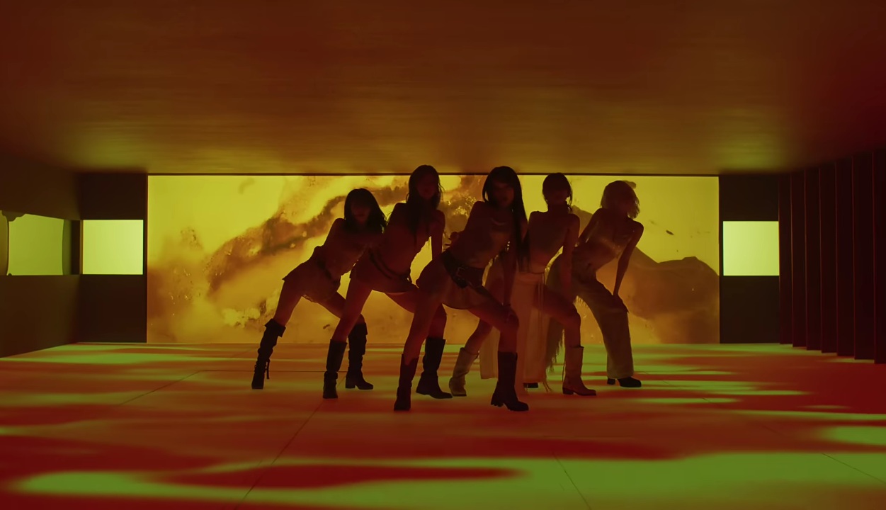 A group shot of LE SSERAFIM dancing in their music video for HOT.