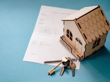 A picture symbolizing homeownership. A house, keys and a contract.